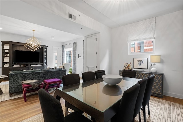 dining space featuring a notable chandelier and light hardwood / wood-style floors