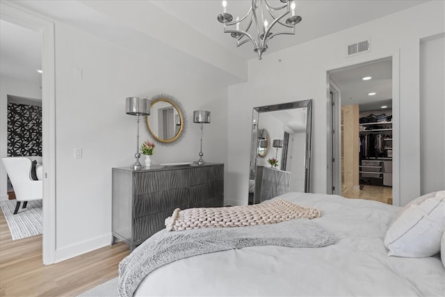 bedroom with hardwood / wood-style floors and a chandelier