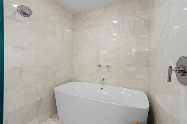 bathroom with tile walls and a tub