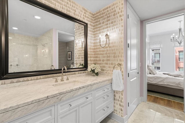 bathroom with vanity, a notable chandelier, and tiled shower