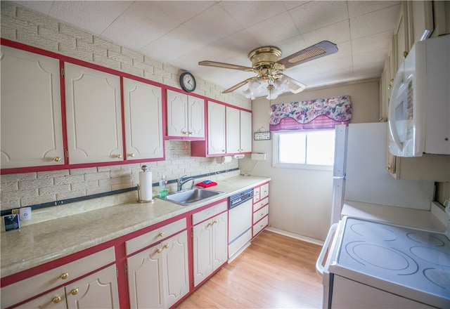 kitchen featuring light hardwood / wood-style floors, sink, decorative backsplash, white appliances, and ceiling fan