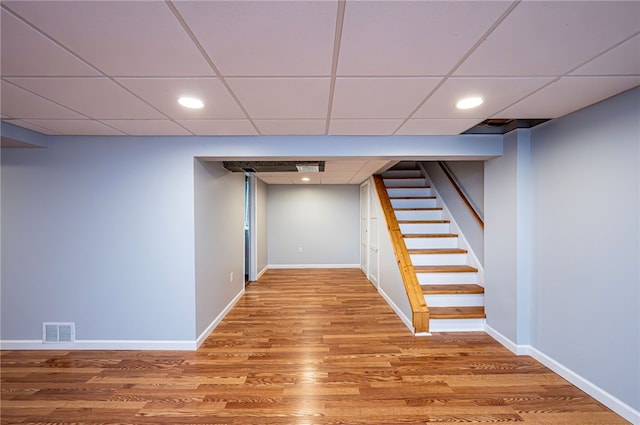 basement with wood-type flooring and a drop ceiling