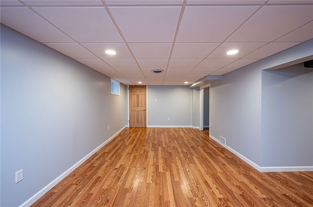 empty room featuring light wood-type flooring and a paneled ceiling