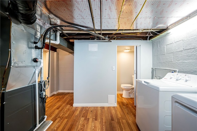 laundry room featuring wood-type flooring and separate washer and dryer