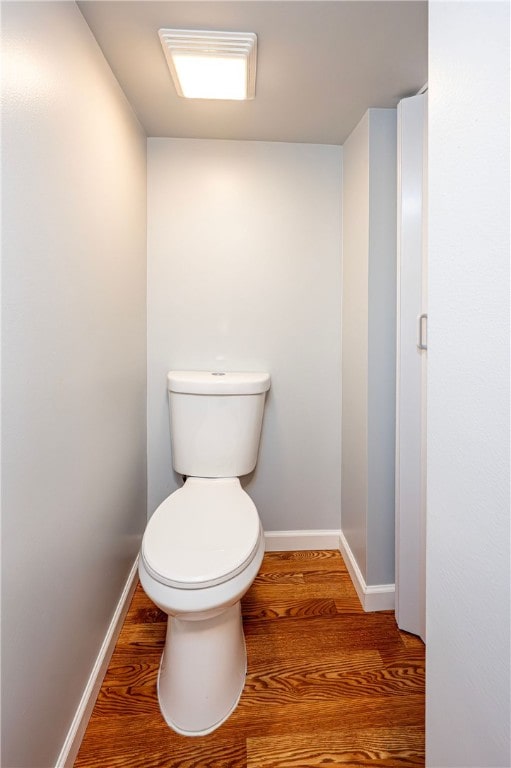 bathroom featuring hardwood / wood-style flooring and toilet