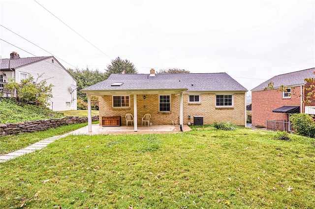 rear view of house featuring a yard, central AC unit, and a patio area