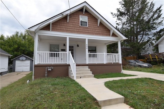 bungalow with a garage, a front lawn, an outdoor structure, and a porch