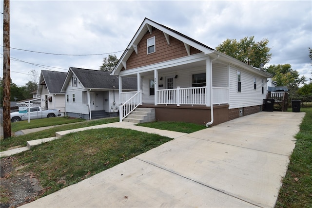 bungalow with a front lawn and covered porch