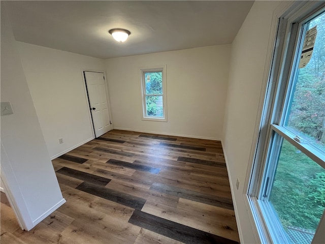 unfurnished room with dark wood-type flooring