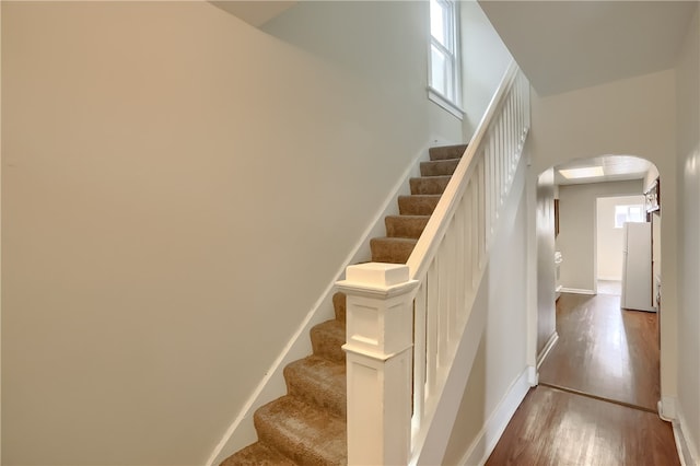 stairs with a high ceiling and hardwood / wood-style flooring