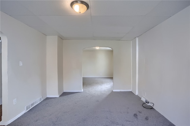 carpeted empty room with a paneled ceiling