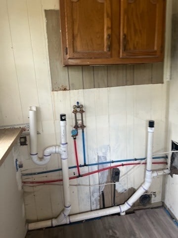 laundry room with wood-type flooring and cabinets