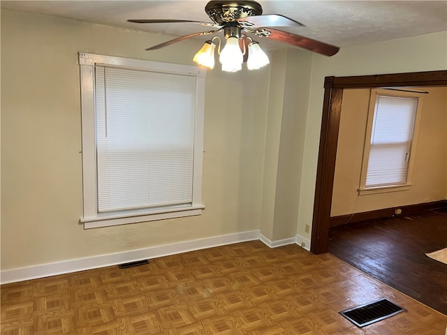 spare room featuring parquet flooring, ceiling fan, and a textured ceiling