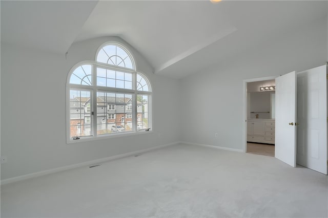 carpeted empty room with vaulted ceiling and plenty of natural light