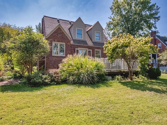 exterior space featuring a wooden deck and a lawn