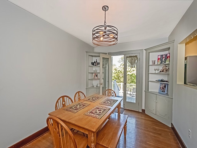 dining space featuring french doors, an inviting chandelier, and hardwood / wood-style floors