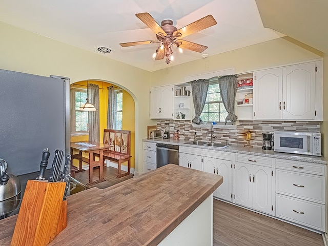 kitchen featuring ceiling fan, sink, butcher block countertops, white cabinetry, and appliances with stainless steel finishes