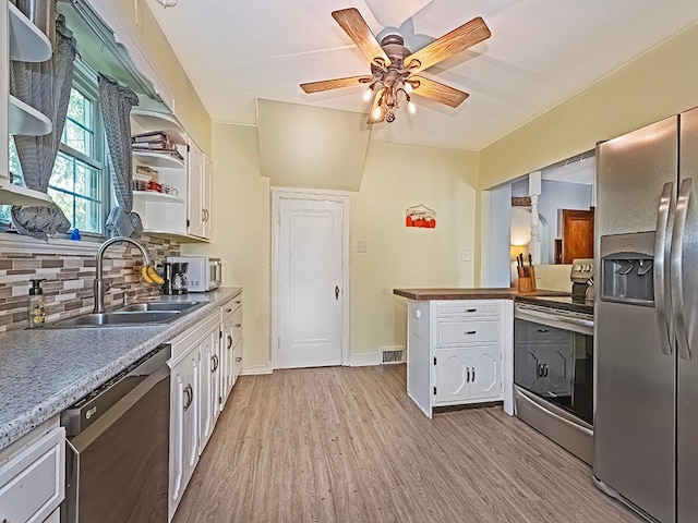 kitchen with white cabinetry, stainless steel appliances, light wood-type flooring, ceiling fan, and sink