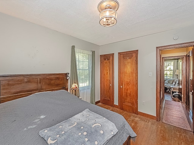 bedroom featuring hardwood / wood-style flooring and a textured ceiling