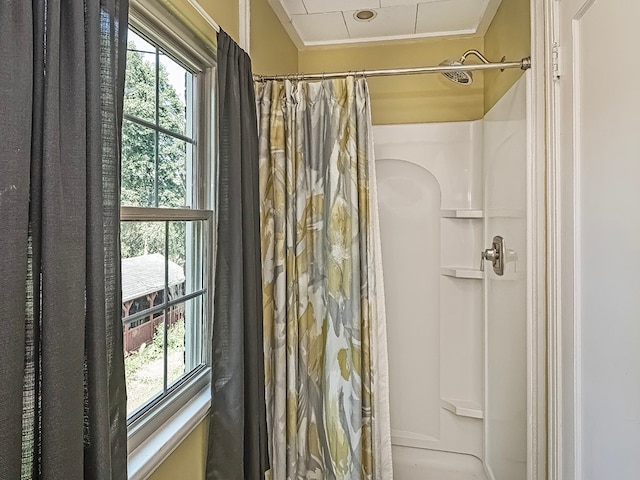 bathroom with crown molding and a shower with shower curtain