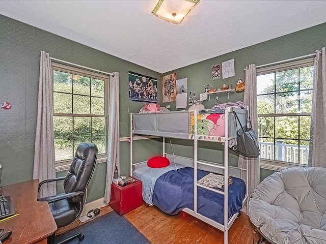 bedroom with multiple windows and wood-type flooring