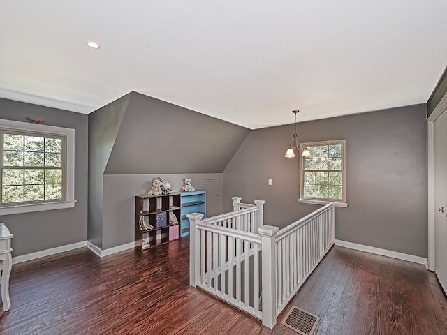 interior space featuring lofted ceiling, a chandelier, and dark wood-type flooring