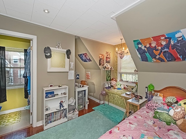 bedroom featuring hardwood / wood-style flooring, lofted ceiling, and a chandelier