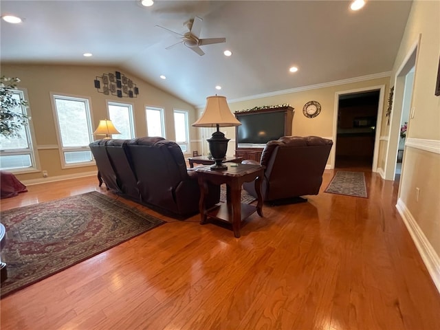 living room with ornamental molding, wood-type flooring, lofted ceiling, and ceiling fan