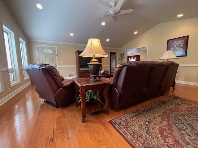 living room with lofted ceiling, ornamental molding, ceiling fan, and light hardwood / wood-style flooring