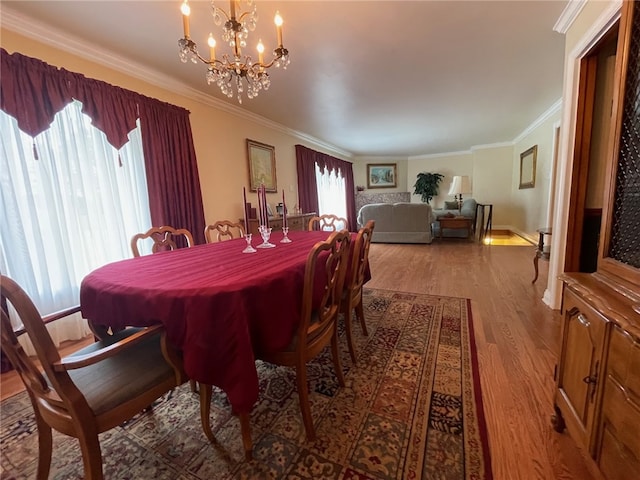 dining area featuring ornamental molding, a notable chandelier, and hardwood / wood-style flooring