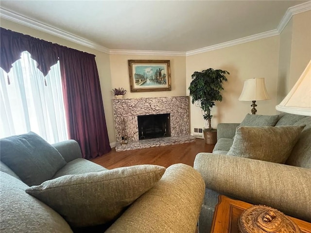living room with ornamental molding, healthy amount of natural light, wood finished floors, baseboards, and a fireplace
