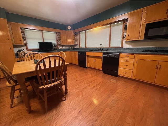 kitchen featuring a healthy amount of sunlight, black appliances, sink, and light hardwood / wood-style flooring