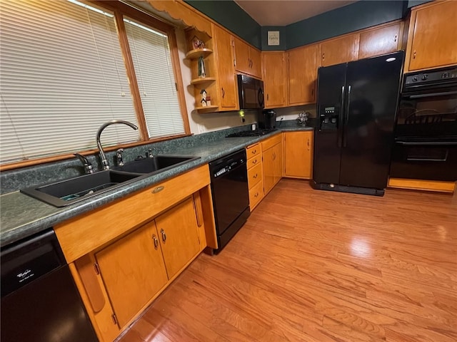 kitchen featuring black appliances, light hardwood / wood-style floors, and sink