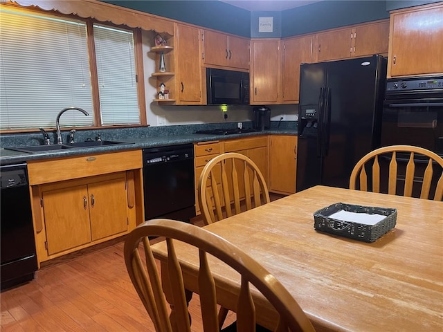 kitchen with sink, light hardwood / wood-style floors, and black appliances