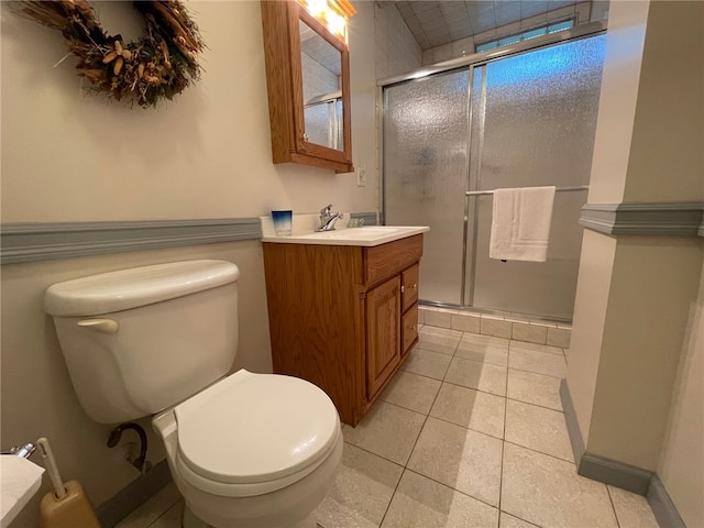 bathroom featuring vanity, toilet, a shower with door, and tile patterned floors