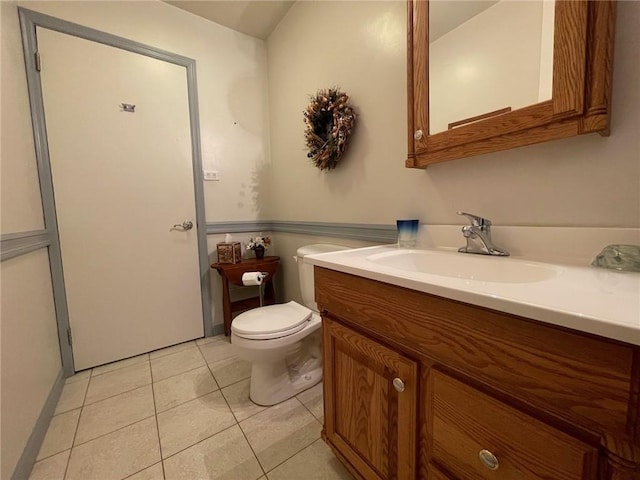 half bathroom featuring toilet, vanity, and tile patterned flooring