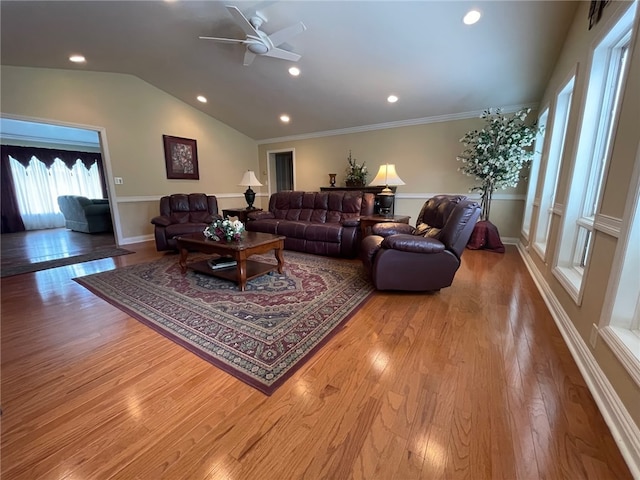 living room with ceiling fan, ornamental molding, light hardwood / wood-style flooring, and vaulted ceiling