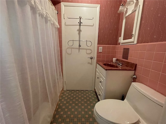 bathroom with vanity, tile walls, toilet, and a shower with shower curtain