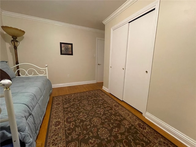 bedroom featuring ornamental molding, hardwood / wood-style floors, and a closet