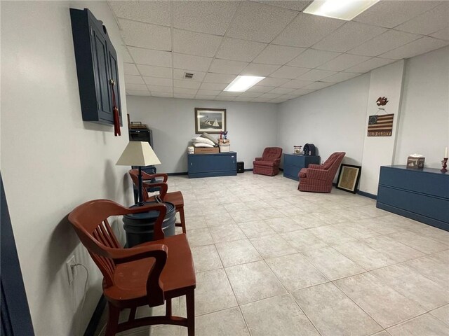 sitting room with a paneled ceiling and light tile patterned floors