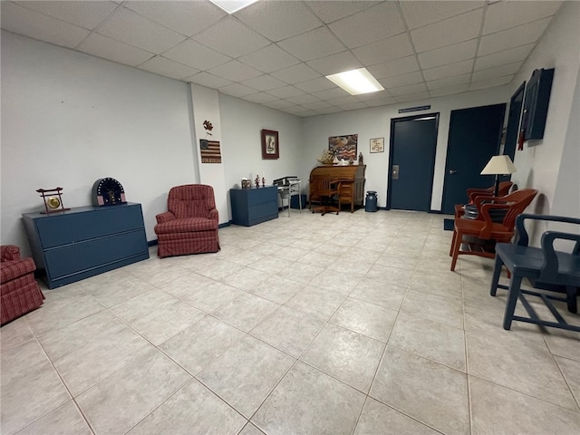 sitting room with a drop ceiling and light tile patterned flooring