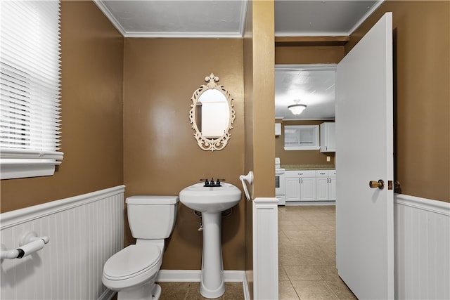 bathroom featuring tile patterned flooring, crown molding, and toilet