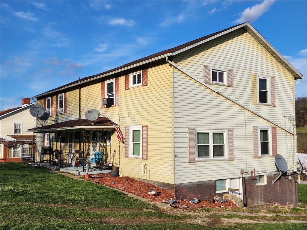 back of house featuring cooling unit, a patio area, and a yard