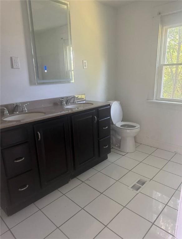 bathroom featuring toilet, vanity, and tile patterned flooring