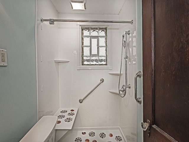 bathroom featuring walk in shower and toilet