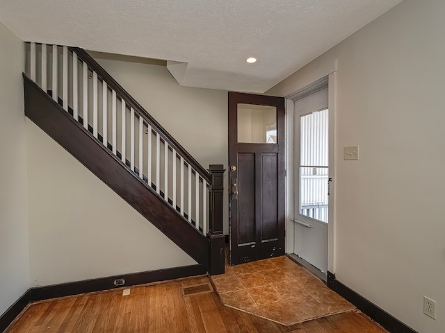 foyer with a textured ceiling and dark hardwood / wood-style flooring