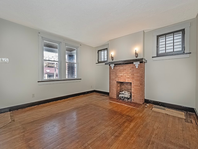 unfurnished living room featuring a textured ceiling, hardwood / wood-style flooring, and a fireplace