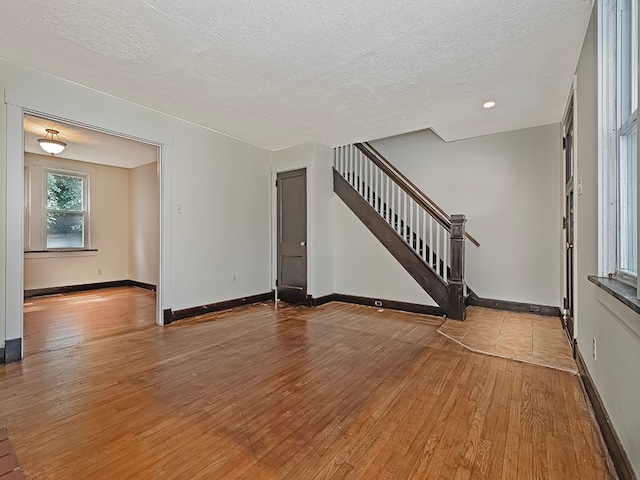 interior space featuring light wood-type flooring and a textured ceiling