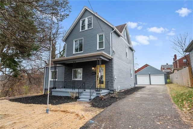 view of property with a garage, an outdoor structure, and covered porch