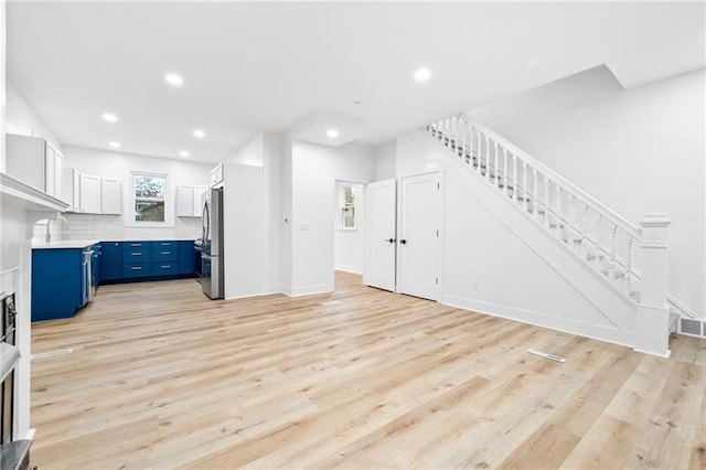 living room with light wood-type flooring and sink